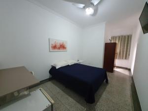 una camera con letto blu di Hotel Jin Ju a Arujá