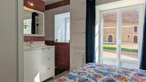 a bedroom with a bed and a sink and a window at Le petit Moulin de la Motte in Bellenot-sous-Pouilly