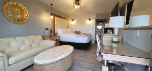 ein Wohnzimmer mit einem Sofa und einem Bett in einem Zimmer in der Unterkunft Dragonfly Inn & Suites in Hastings