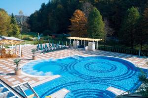 uma grande piscina com água azul num pátio em Hotel Vitarium Superior - Terme Krka em Smarjeske Toplice