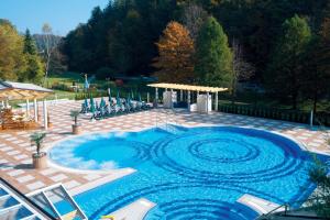 einen großen Pool mit blauem Wasser auf einer Terrasse in der Unterkunft Hotel Vitarium Superior - Terme Krka in Smarjeske Toplice