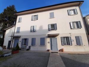 a large white house with blue shuttered windows at Reggiolacittàinvisibile B&B in Reggio Emilia