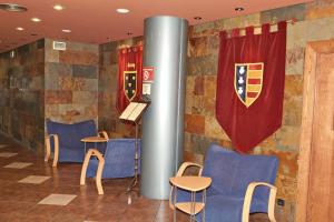 a room with blue chairs and a pillar and a flag at Hotel Yerri in Estella