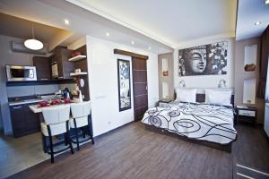 ein Schlafzimmer mit einem Bett und eine Küche mit einer Bar in der Unterkunft Németh Apartmanok in Sárvár