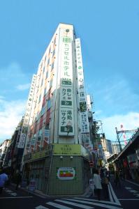 a tall building with writing on the side of it at Anshin Oyado Tokyo Shinbashi Ekimaeten-Male Only in Tokyo