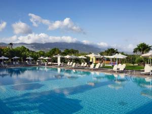 une grande piscine avec des chaises et des parasols dans l'établissement Atlantica Thalassa Hotel, à Kos