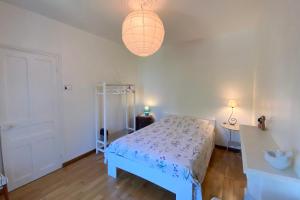 a white bedroom with a bed and a lamp at CARANTEC FAMILY HOME WITH GARDEN 6 persons in Carantec