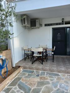a patio with a table and chairs and a door at Flisvos Apartments in Megalochori