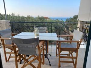 a table and chairs on a balcony with a view at Flisvos Apartments in Megalochori