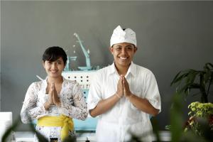 un hombre y una mujer rezando en una habitación en 7 Bidadari Hotel Seminyak, en Seminyak