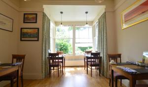 a dining room with a table and chairs and a window at Fairfield House and Gardens in Bowness-on-Windermere