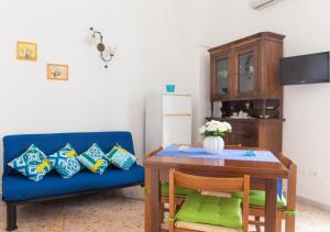 - un salon avec un canapé bleu et une table dans l'établissement Casa Rosetta con terrazza panoramica by Wonderful Italy, à Ostuni