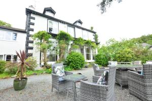 鲍内斯温德米尔Fairfield House and Gardens的房屋前设有椅子和桌子