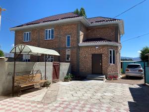 a brick house with a bench in front of it at Guest House Baytur in Kochkor