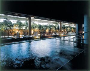 a large swimming pool in a building with trees at Yunokuni Tensyo in Kaga