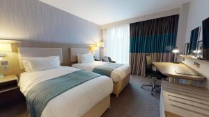 um quarto de hotel com duas camas e uma secretária em Holiday Inn Manchester - City Centre, an IHG Hotel em Manchester