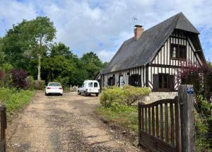 dom z dwoma samochodami zaparkowanymi na polnej drodze w obiekcie Gîte Normand à 10mn d'Honfleur w mieście Genneville