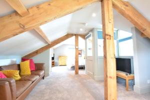 a living room with a couch and a tv at Fairfield House and Gardens in Bowness-on-Windermere