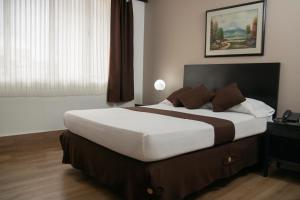 Un pat sau paturi într-o cameră la Hotel Americana