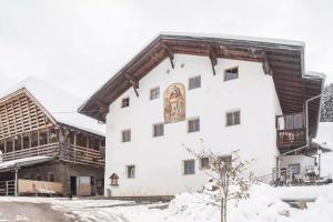 un grande edificio bianco con un tetto di legno di Ladinser Hof Kuschelecke a Castelrotto