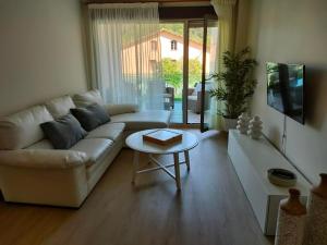a living room with a white couch and a table at Apartamentos Boutique Arquera Golf I in Llanes
