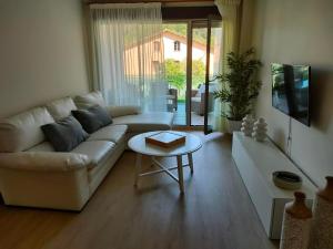 uma sala de estar com um sofá branco e uma mesa em Apartamentos Boutique Arquera Golf I em Llanes