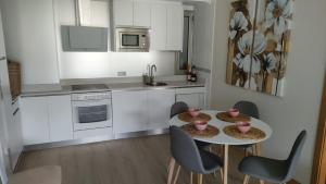 a kitchen with a table and chairs in a kitchen at Apartamentos Boutique Arquera Golf I in Llanes