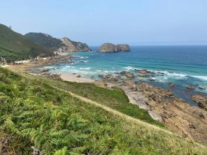 a view of a beach with rocks and the ocean at Apartamentos Boutique Arquera Golf I in Llanes