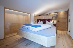a bedroom with a large bed with blue sheets at Ladinser Hof Western Suite in Castelrotto