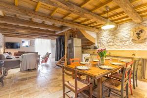 a kitchen and living room with a wooden table and chairs at La Maison au Comptoir in Aiserey