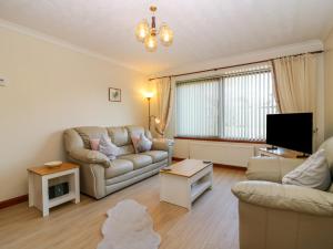 a living room with a couch and a tv at 48 Edenbank Road in Cupar