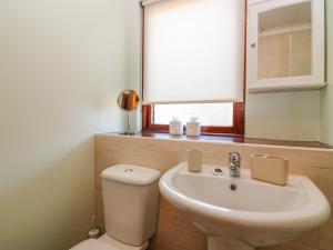 a bathroom with a toilet and a sink and a mirror at 48 Edenbank Road in Cupar +17 photos
