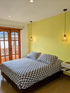 a bedroom with a bed and two lights on the wall at OFF HOSTEL in Villa de Leyva