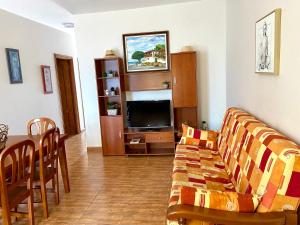 a living room with a couch and a tv at Casa Los Palmeros Perdomo in Alojera