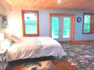 - une chambre avec un lit dans une pièce dotée de fenêtres dans l'établissement LAKEFRONT Home at Lake Chickamauga! Walk to the Marina!, à Dayton