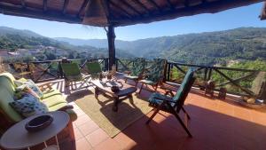 a balcony with chairs and a view of the mountains at Gerês - Refúgio das Laranjeiras in Geres