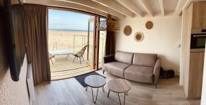 a living room with a couch and a table at Breezand Beachhouses in Vrouwenpolder