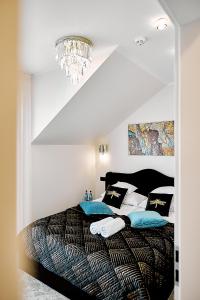 1 dormitorio con 1 cama grande y lámpara de araña en Złota Nuta Villa, en Mikołajki
