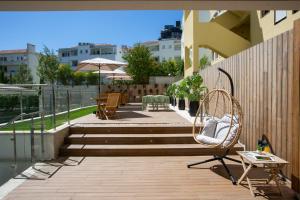 eine Terrasse mit Treppen, Stühlen und Tischen auf einem Gebäude in der Unterkunft Casual Raízes Porto in Porto