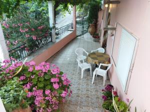 balcón con mesa, sillas y flores en Garden Of Olive Trees en AsfendhilÃ©s