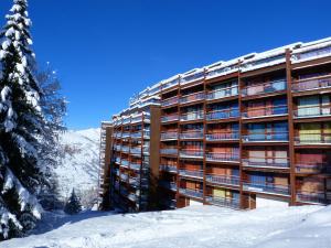 ein großes Gebäude im Schnee mit einem Baum in der Unterkunft Appartement Les Arcs 1800, 2 pièces, 5 personnes - FR-1-411-596 in Arc 1800