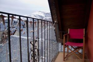 a pink chair sitting on a balcony with a snow covered mountain at Hotel Saueth in Tredós