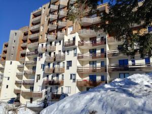 an apartment building with snow in front of it at Appartement Les Adrets-Prapoutel, 1 pièce, 3 personnes - FR-1-557-10 in Les Adrets