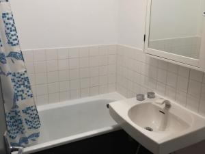 a white bathroom with a sink and a bath tub at Appartement Les Adrets-Prapoutel, 1 pièce, 4 personnes - FR-1-557-75 in Les Adrets