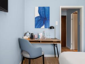 una scrivania in una camera con parete blu di numa I Artol Rooms & Apartments a Dusseldorf
