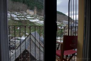 a view of a balcony with a table and a chair at Hotel Saueth in Tredós