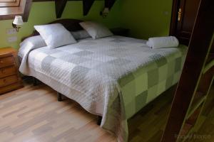 a bedroom with a bed with a checkered blanket at Hotel Saueth in Tredós