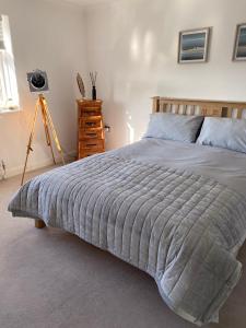 a bedroom with a large bed and a tripod at Driftwood Lodge in Llansantffraid Glan Conwy