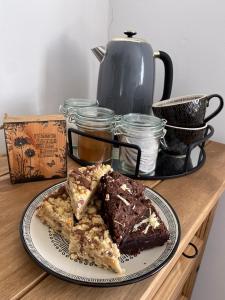 talerz z dwoma kawałkami ciasta na stole w obiekcie Driftwood Lodge w mieście Llansantffraid Glan Conwy
