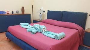 um quarto com uma cama com lençóis azuis e cor-de-rosa em Villa Sargheruoli em Monteroni di Lecce